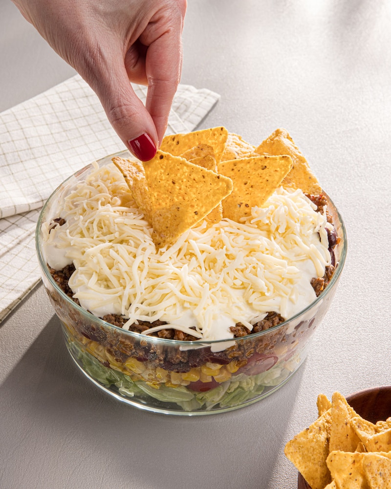 Dieses Bild zeigt wie die Tacos auf den Salat gegeben wird.