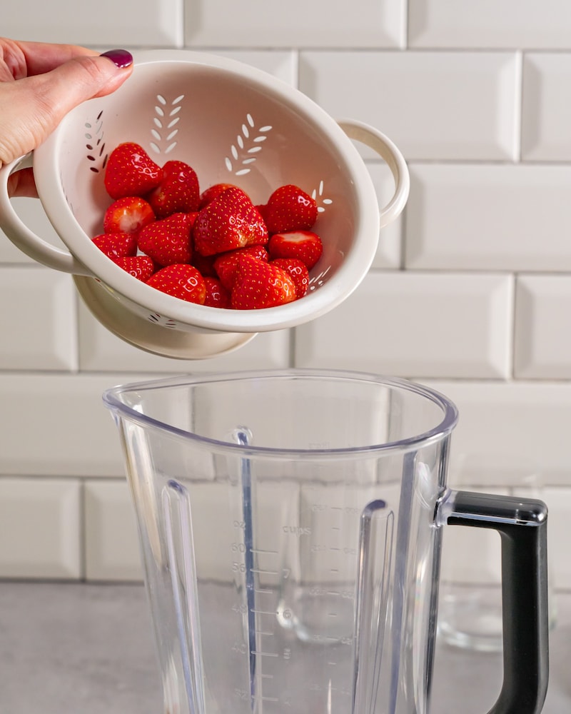 Dieses Bild zeigt wie die Erdbeeren in den Mixer gegeben werden.