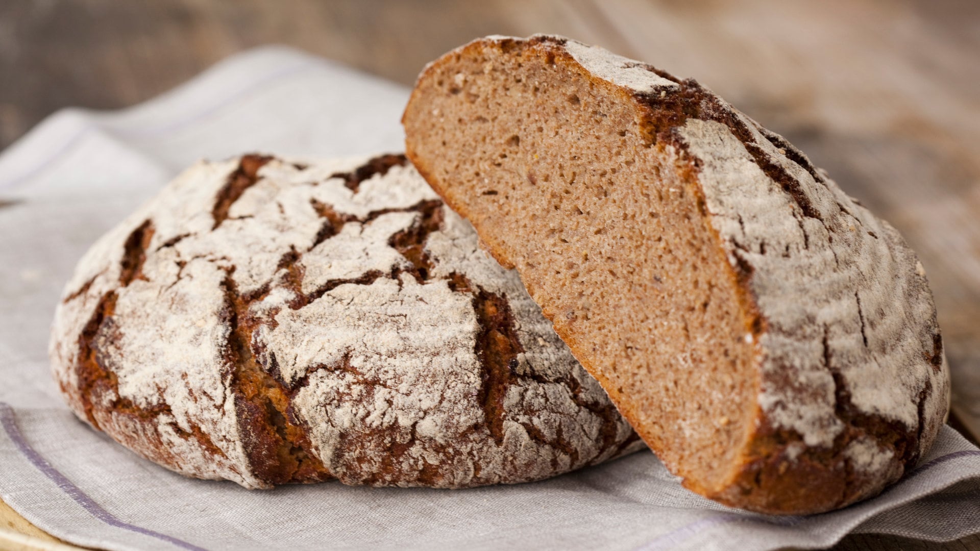 Aufgebrochens Laib Brot auf einem Küchentuch.