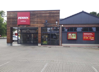 Sie sehen den Eingang vom Penny Markt in Golßen Straße der Einheit 7