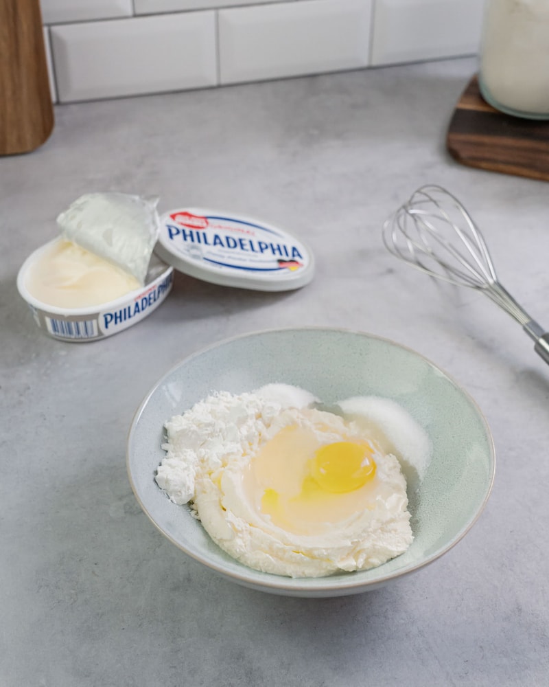 Dieses Bild zeigt, wie Frischkäse und Ei vermischt werden.