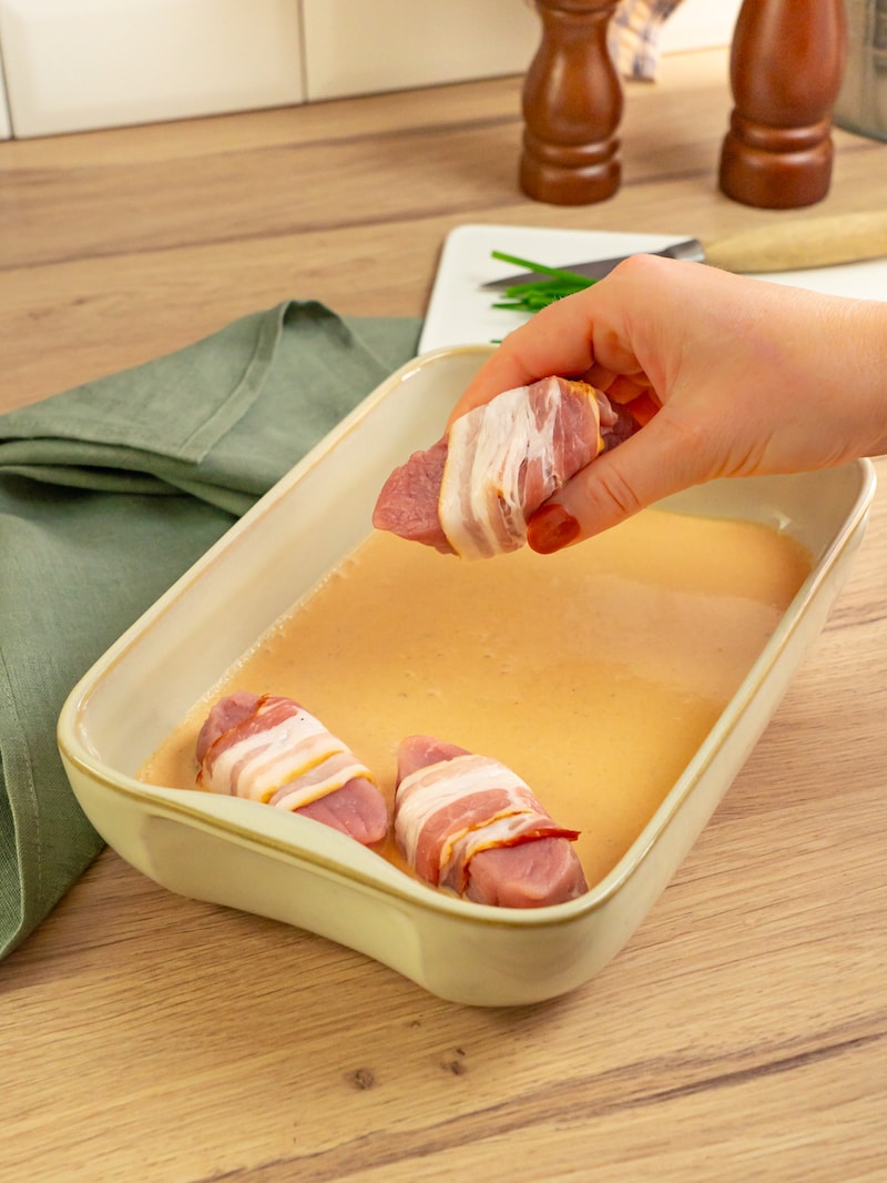 Dieses Bild zeigt wie die Schweinefilets zur Soße gegeben werden.