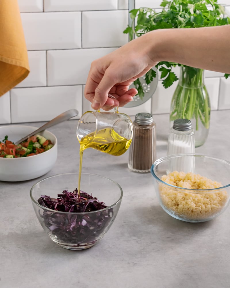 Dieses Bild zeigt wie der Rotkohl mit Öl übergossen wird.