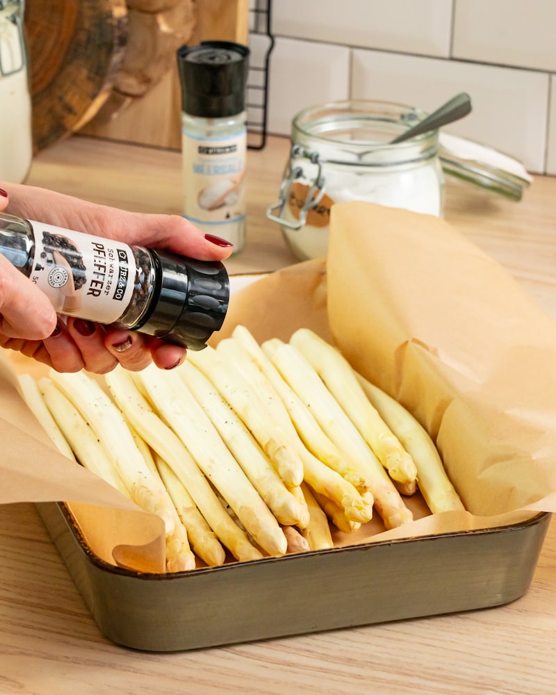 Dieses Bild zeigt wie der Spargel gewürzt  wird.