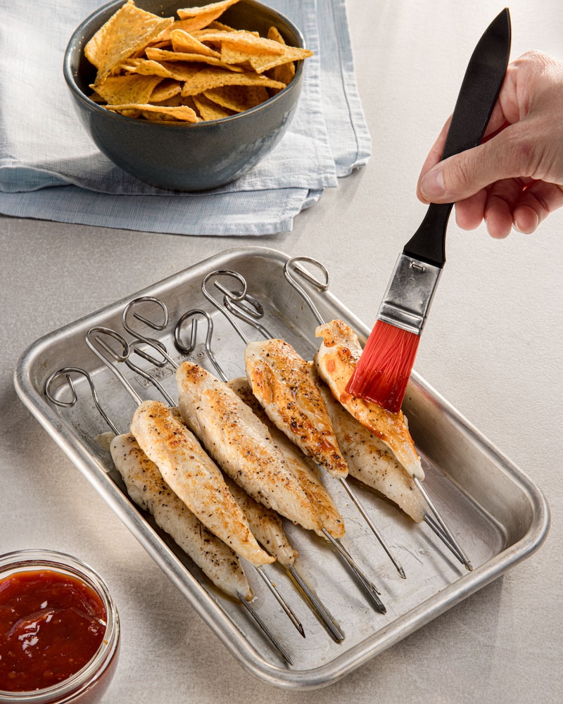 Dieses Bild zeigt wie das Chicken mit BBQ-Soße bestrichen wird.