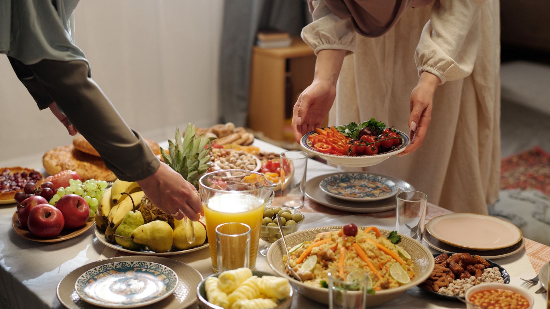 Tisch wird mit unterschiedlichen Gerichten gedeckt