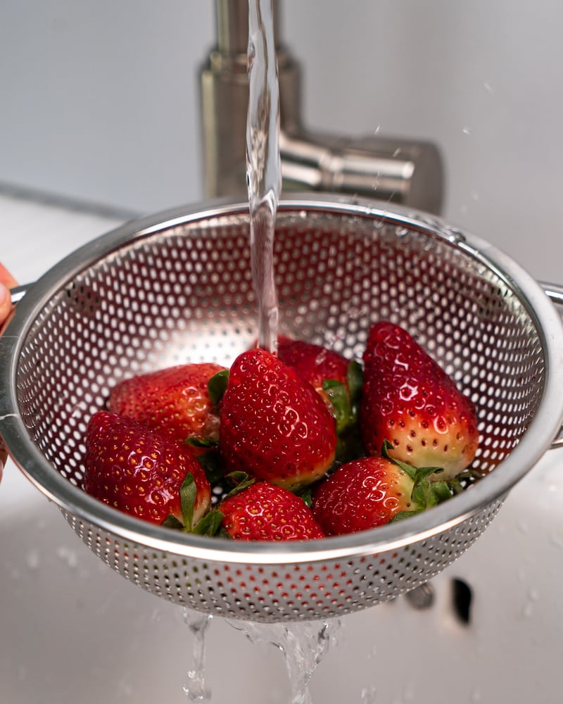 Auf diesem Bild siehst du wie Erdbeeren abgewaschen werden.