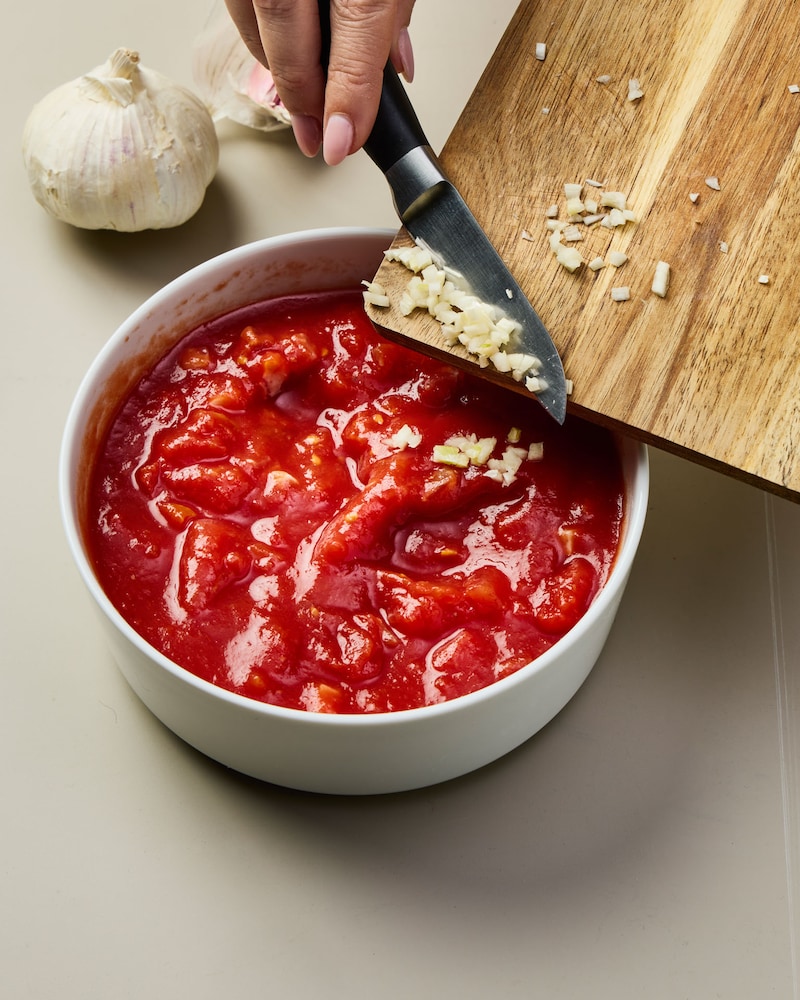 Dieses Bild zeigt wie der Knoblauch zur Soße gegeben wird.
