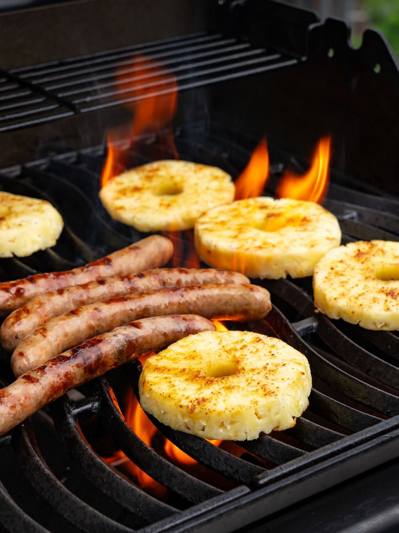 Dieses Bild zeigt die Ananas und die Würstchen auf dem Grill.