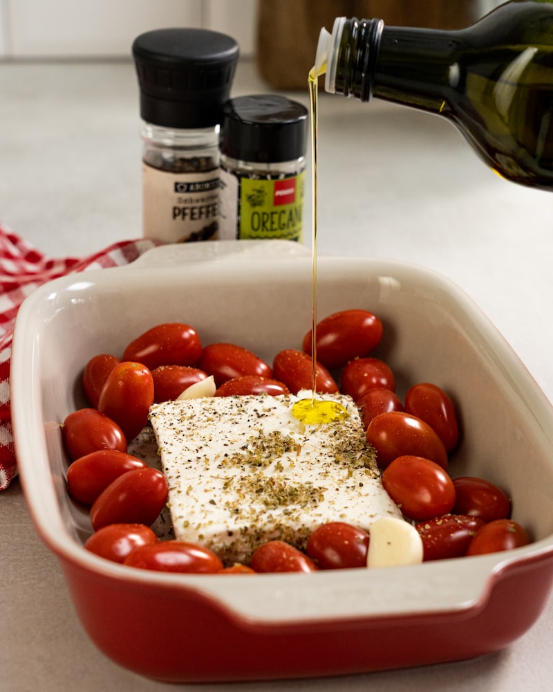 Auf diesem Bild siehst du wie der Feta mit Öl begossen wird.