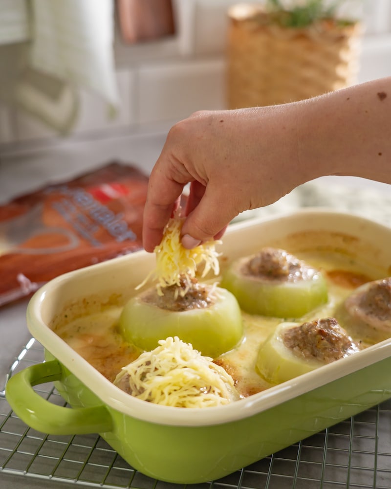 Dieses Bild zeigt wie Käse über den Kohlrabi gegeben wird.