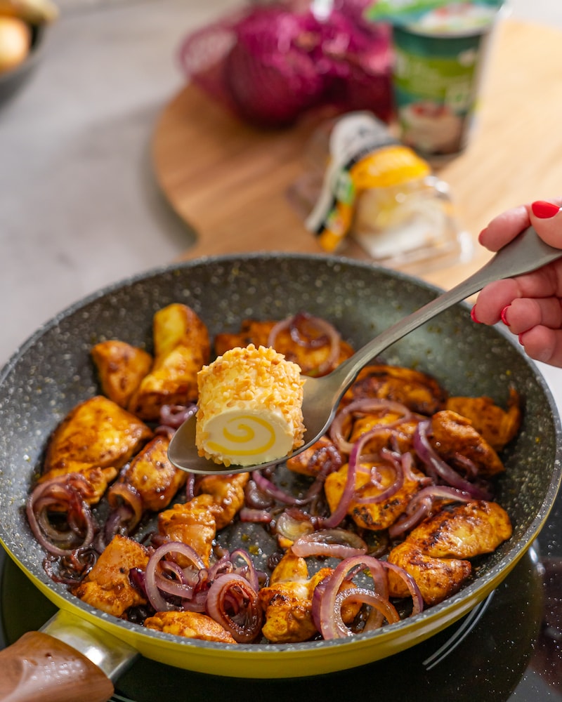 Diese Bild zeigt das Hähnchen und die Zwiebeln in der Pfanne.
