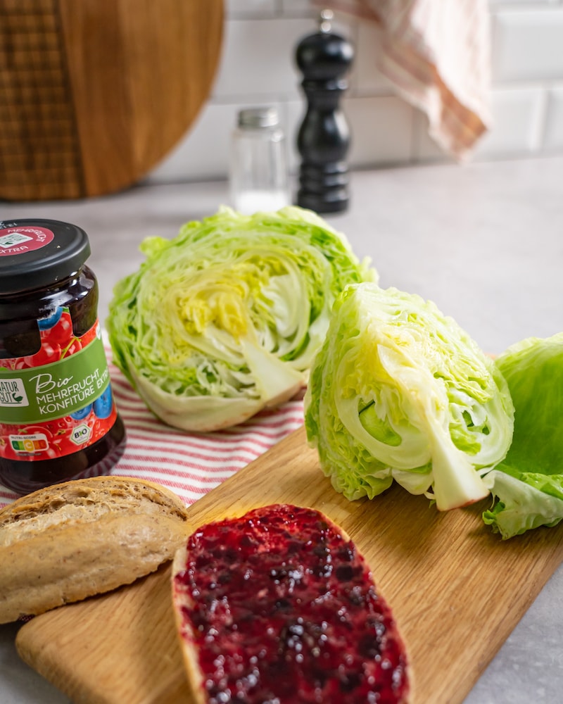 Dieses Bild zeigt das Marmeladen-Brötchen mit einem aufgeschnittenen Salatkopf.