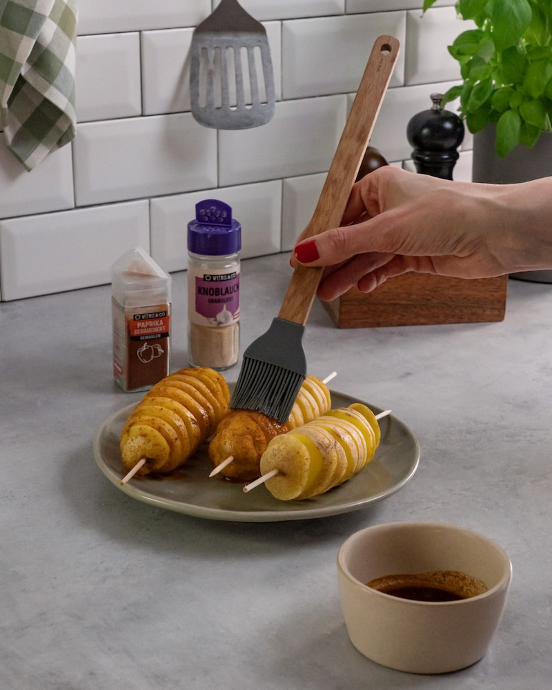 Dieses Bild zeigt, wie Kartoffeln bepinselt werden.