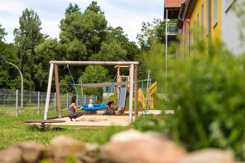 Muetter und Kinder beim Spielen auf dem Spielplatz