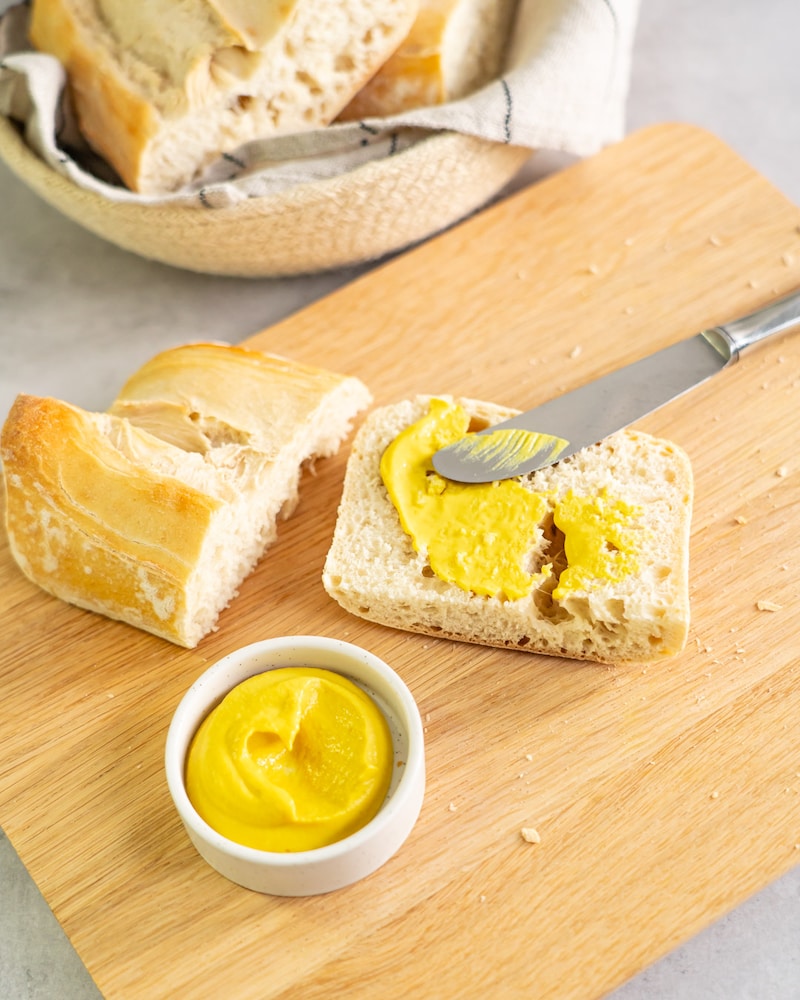 Dieses Bild zeigt wie die Ciabatta Hälften mit Senf bestrichen werden.