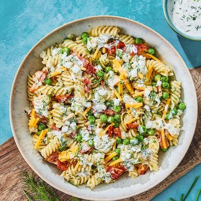 Dieses Bild zeigt den fertigen Nudelsalat mit Knusperbacon und grünen Erbsen.