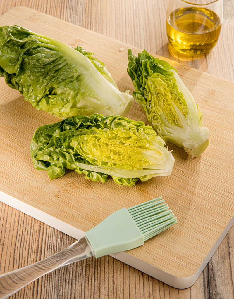 Dieses Bild zeigt wie der Salat mit Öl bestrichen wird.