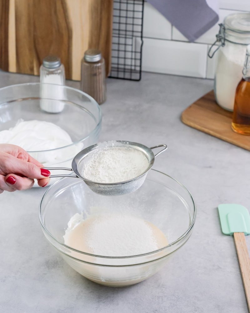 Dieses Bild zeigt wie die trockenen Zutaten gesiebt werden.