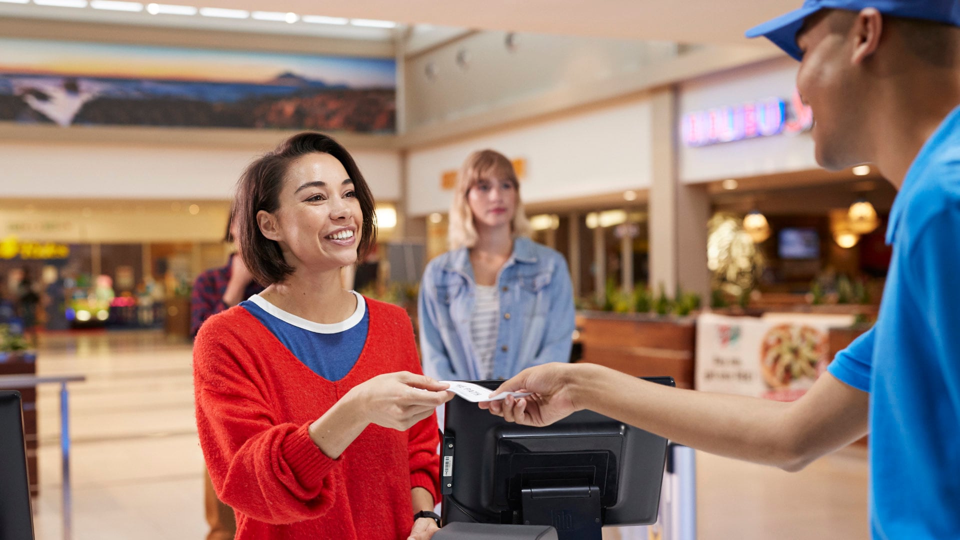 Kassiere reicht Frau Kassenzettel