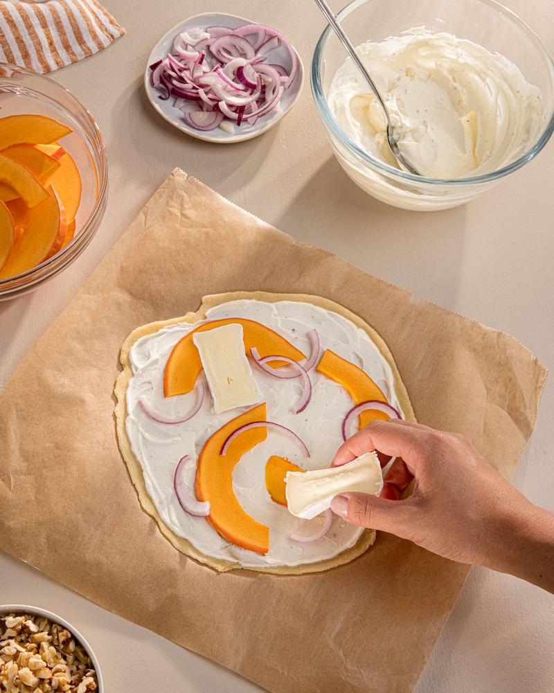 Dieses Bild zeigt wie der Flammkuchen belegt wird.