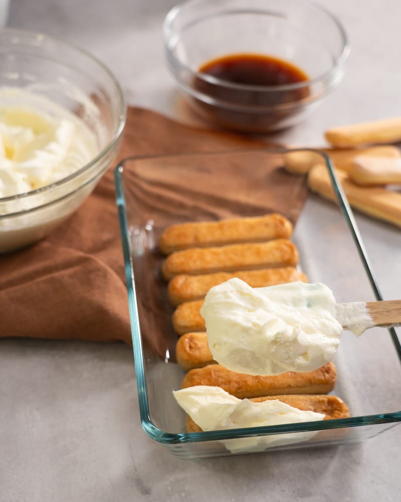 Dieses Bild zeigt wie die Creme auf die Löffelbisquits gegeben wird.