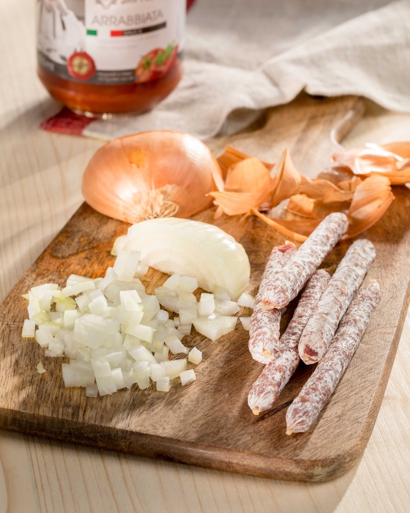 Auf diesem Bild siehst du geschnittene Zwiebeln und Salami Stixx.