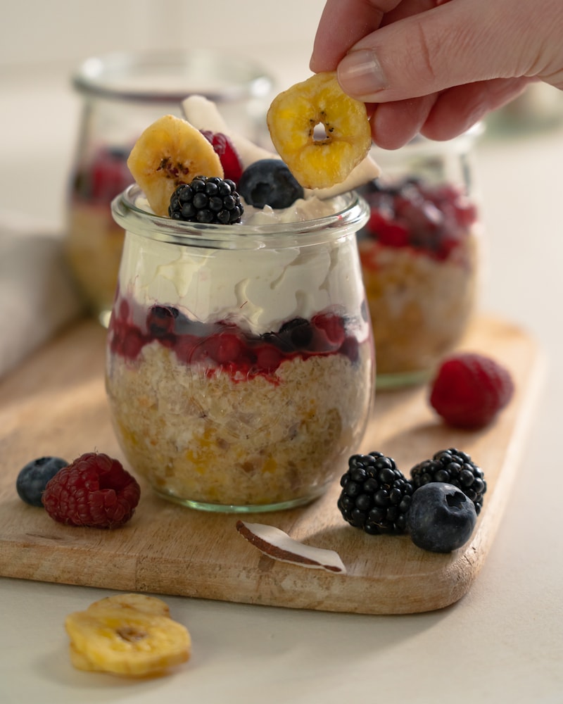 Auf diesem Bild siehst du wie das Dessert mit Früchten garniert wird.