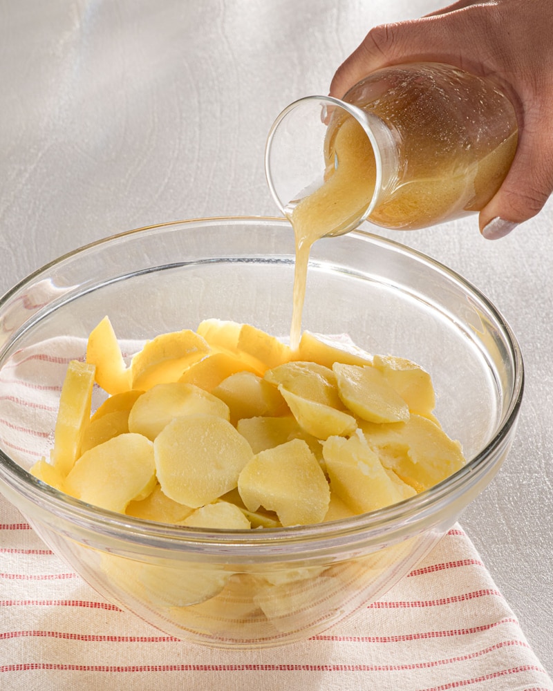 Dieses Bild zeigt wie das Dressing über die Kartoffeln gegeben wird.