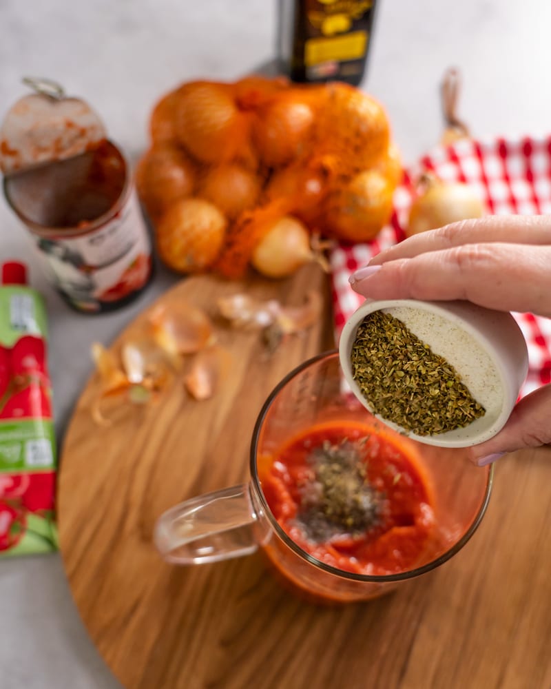 Dieses Bild zeigt wie Oregano dazugegeben wird.