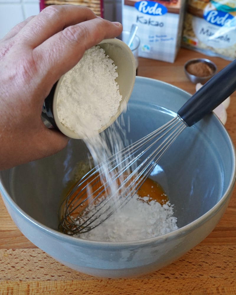 Dieses Bild zeigt wie der Puderzucker hinzugegeben wird.