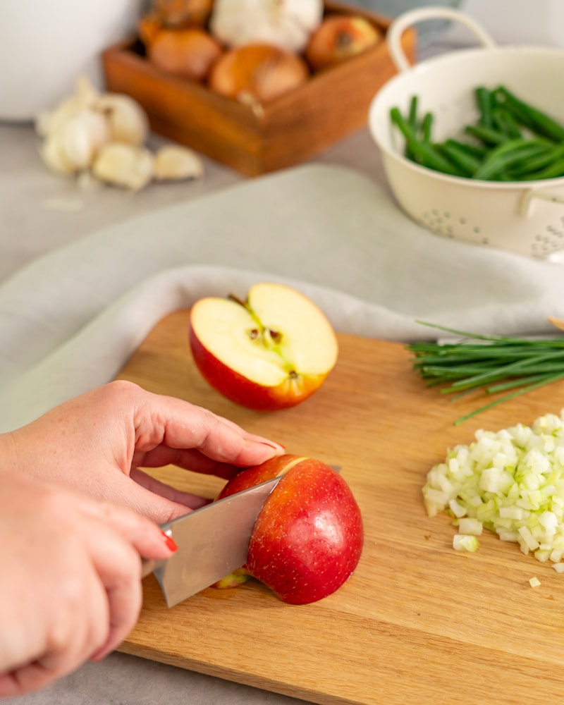 Dieses Bild zeigt wie der Apfel und die Zwiebeln geschnitten werden.