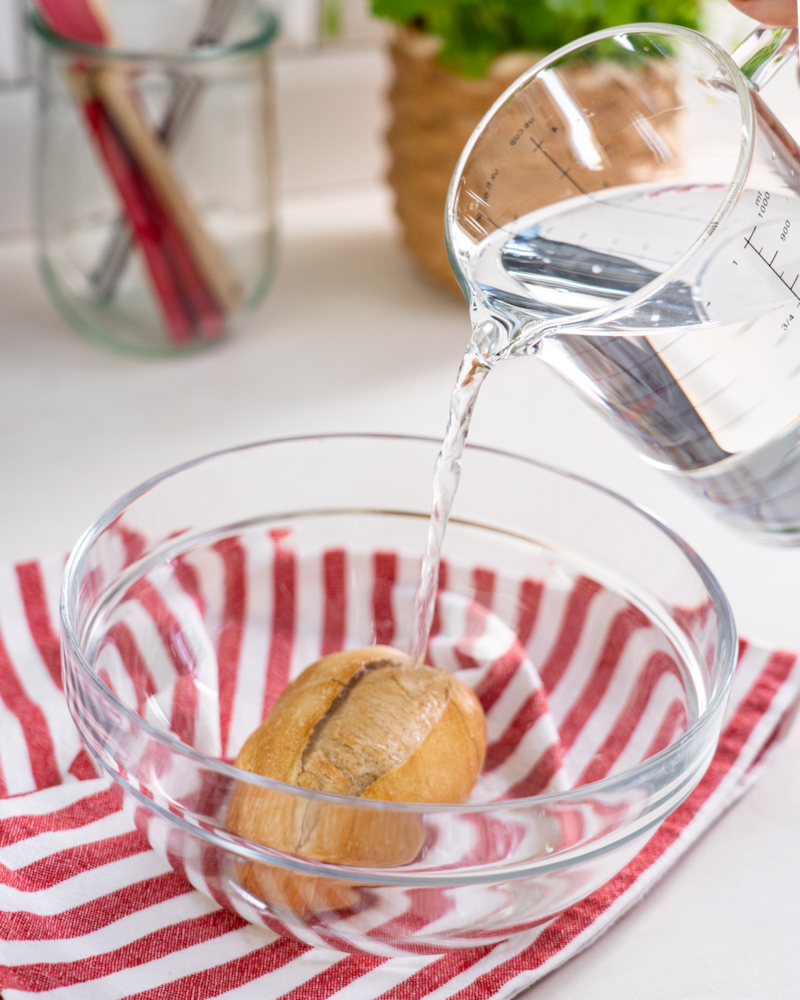 Auf diesem Bild siehst du wie ein Brötchen in Wasser gelegt wird.