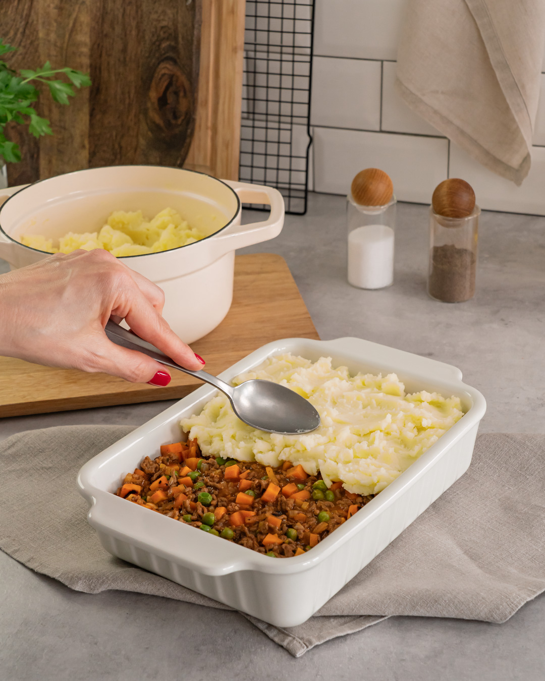 Dieses Bild zeigt wie mit Kartoffelpüree abgedeckt wird.