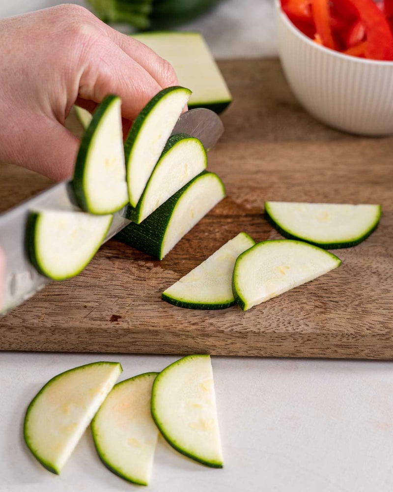 Auf diesem Bild siehst du wie Zucchinis geschnitten werden.
