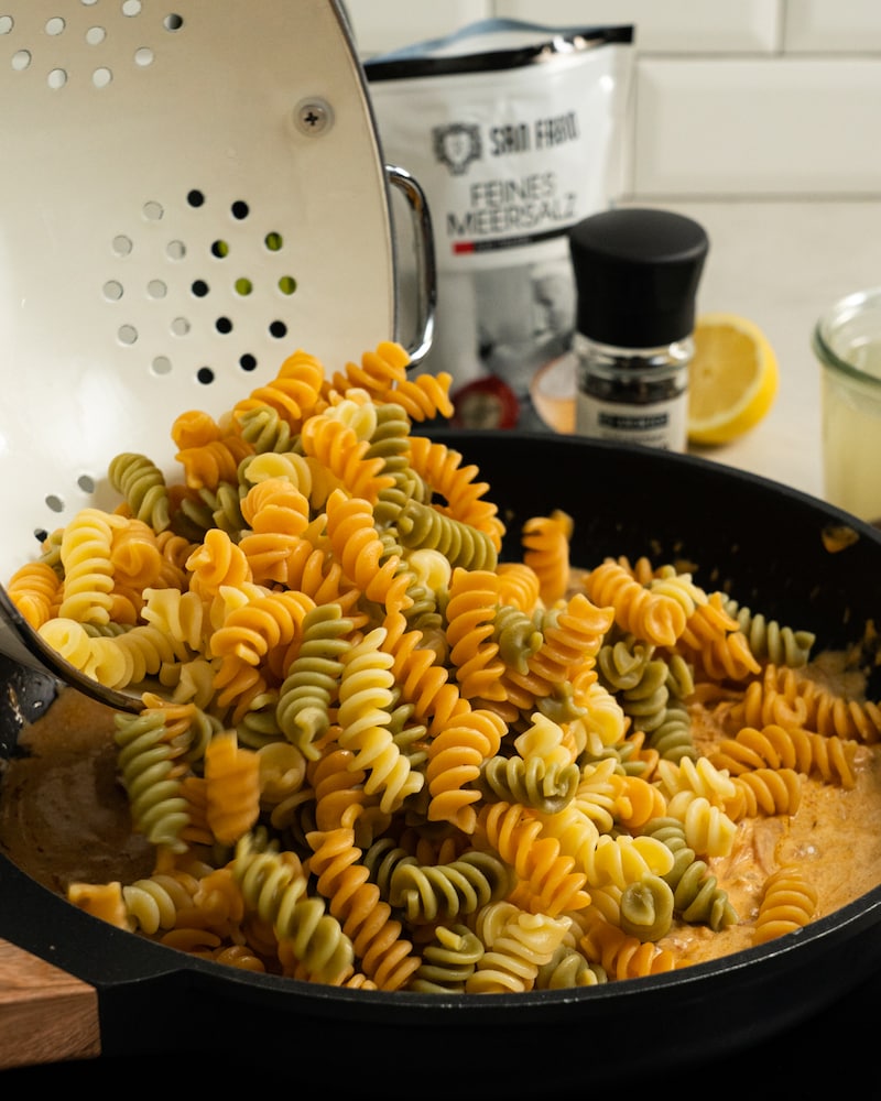 Auf diesem Bild siehst du wie die Fusilli in die Pfanne gegeben werden.