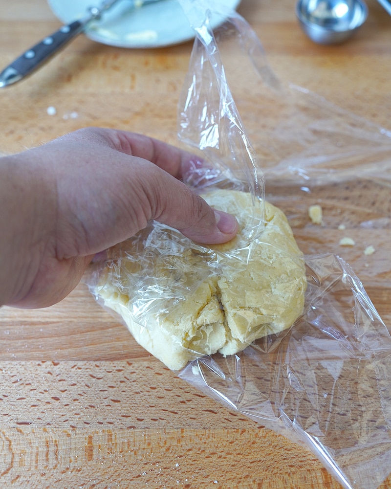 Dieses Bild zeigt wie der Teig in Klarsichtfolie eingeschlagen wird.