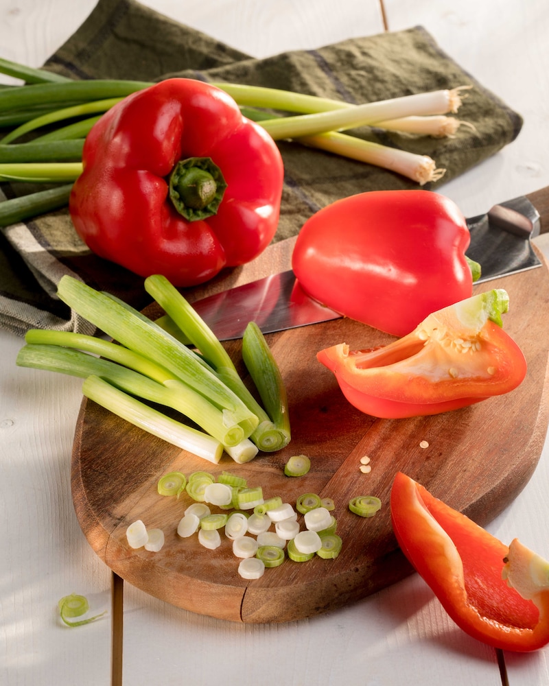 Auf diesem Bild siehst du geschnittene Paprika und Frühlingszwiebeln.