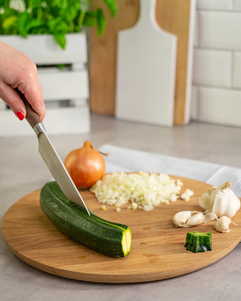 Dieses Bild zeigt wie die Zwiebeln, Knoblauch und Zucchini vorbereitet werden.