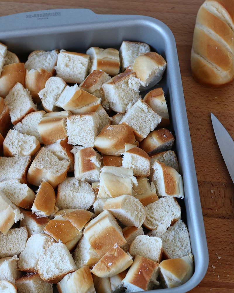 Auf diesem Bild siehst du klein geschnittene Milchbrötchen in einer Auflaufform.