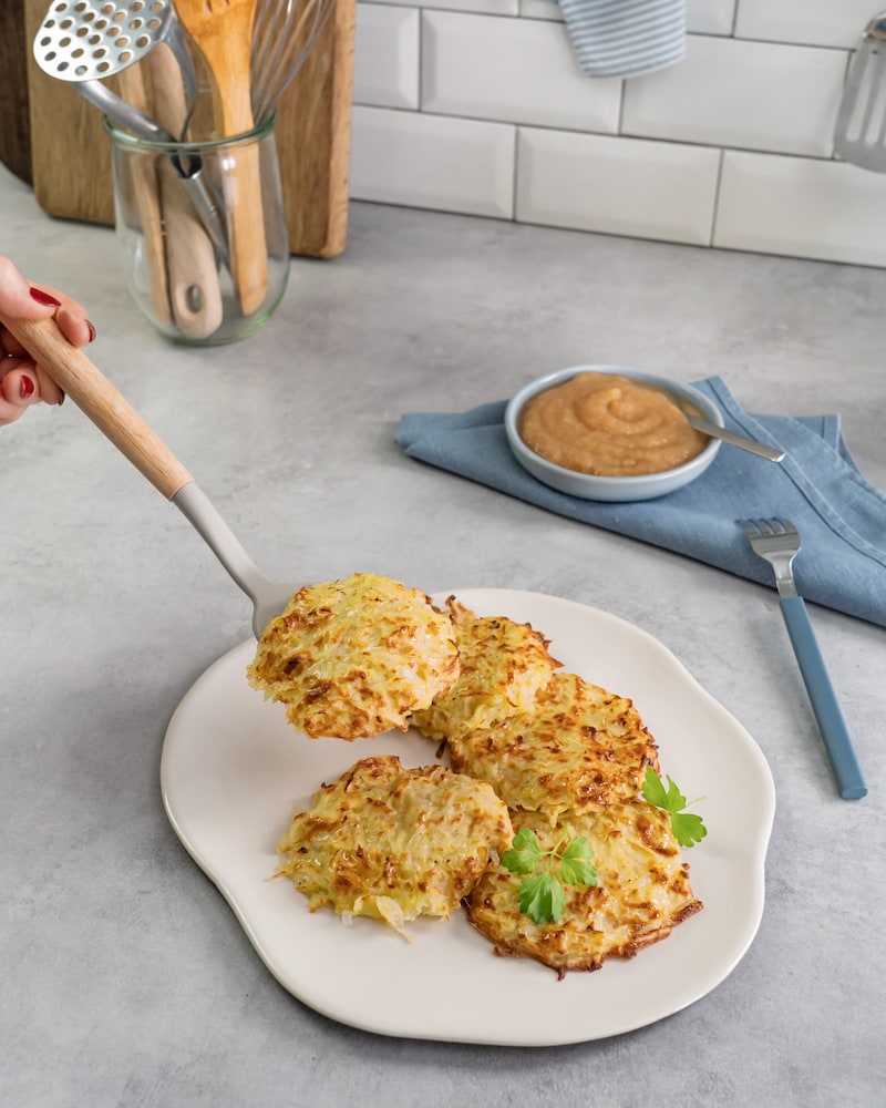 Diese Bild zeigt wie die fertigen Kartoffelpuffer aus der Heißluftfritteuse mit Apfelmus serviert werden.