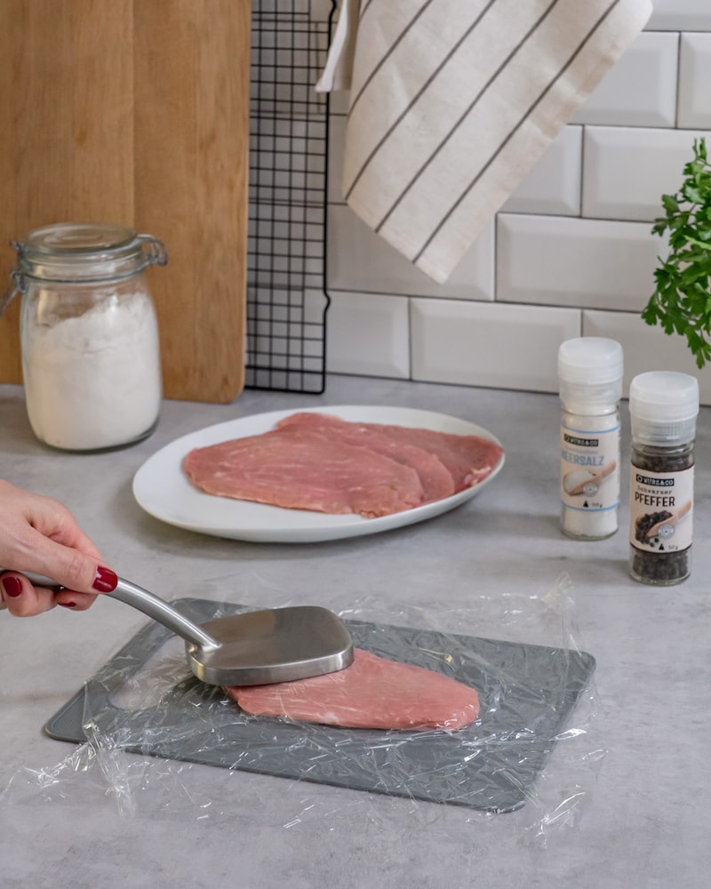 Diese Bild zeigt wie das Fleisch plattgeklopft wird.