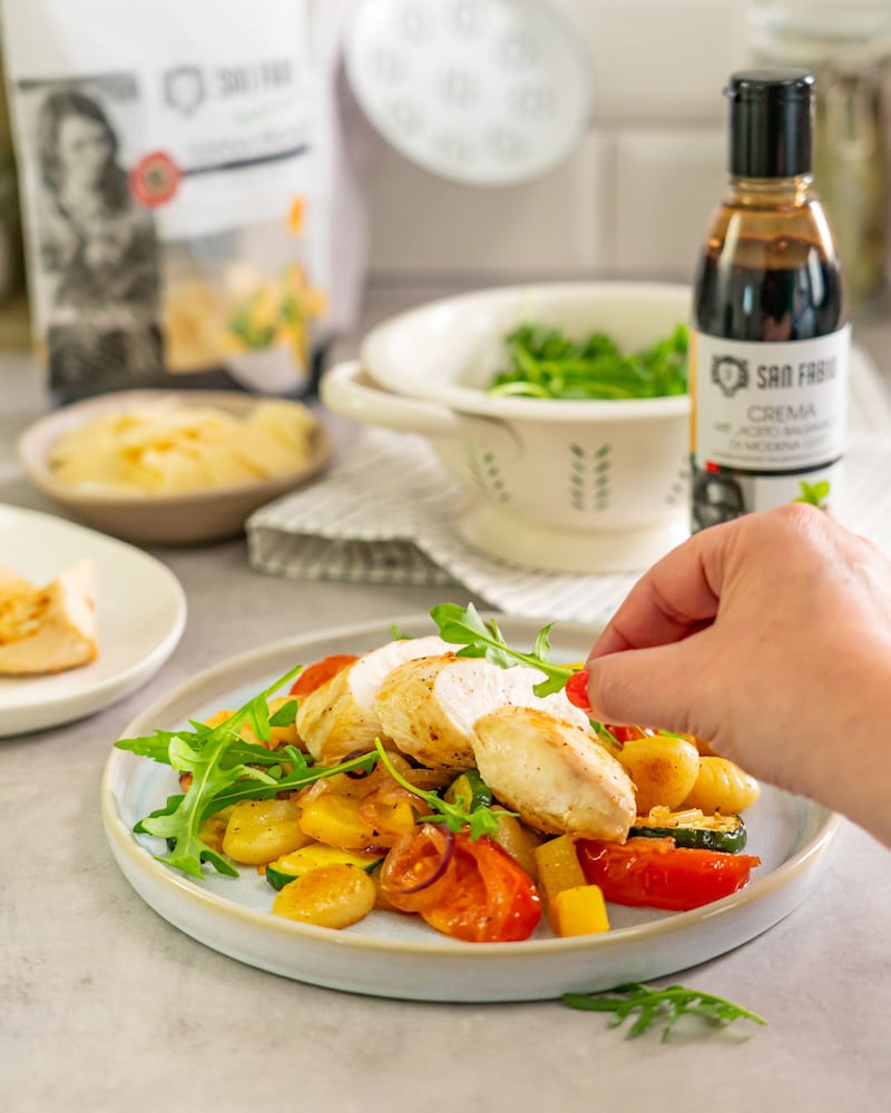 Dieses Bild zeigt wie der Rucola auf den Gnocchi Salat gegeben wird.